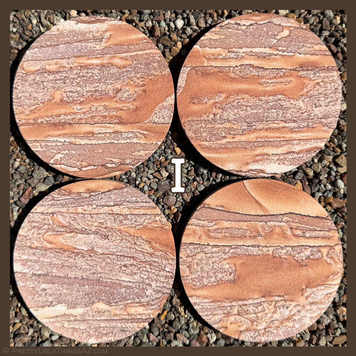 Option I, four coasters with quite different pattern from the rest of the options. They are covered with angular horizontal streaks of a red sandstone color and a mottled white and light brick-red color, which gives them a light pinkish coloration overall.