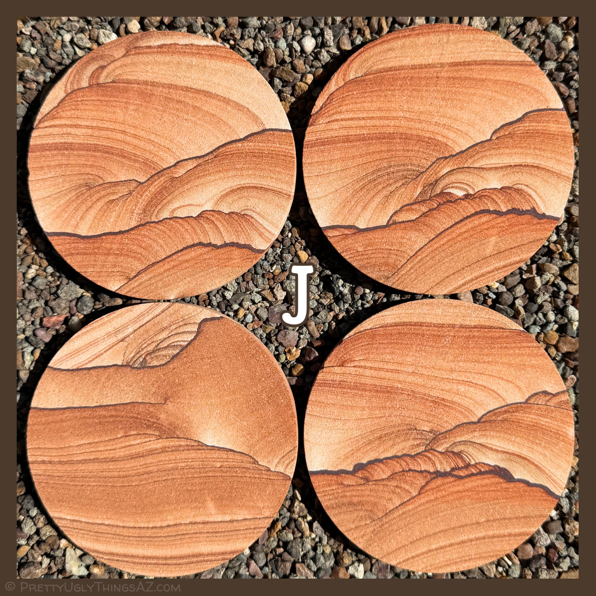 Option J, four coasters with very good scenic patterning, with dark iron bands tapered from medium to very thin and with scallop patterns, resembling hills or a landscape. Softer sweeping layers above appear as sky.