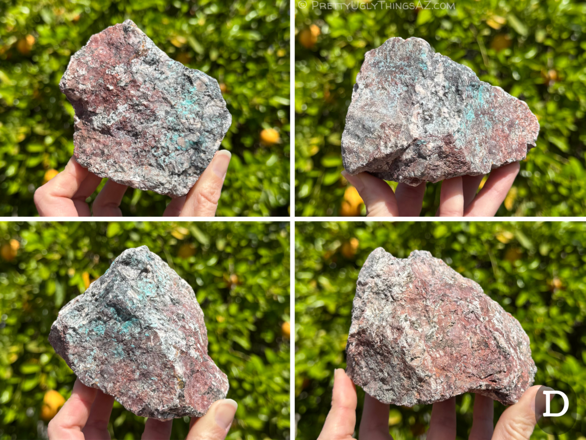 Option D, a compact blocky piece with dark red-brown iron oxides covering one end. The other end is a light granite speckled black with chunky feldspar crystals. Light blue mineral is sprinkled across the middle, subtle on this piece.