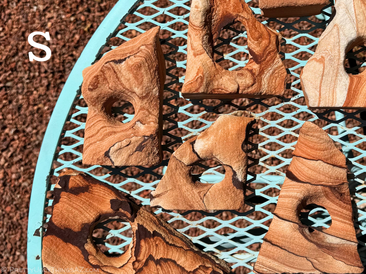 Red sandstone arches spread over a tabletop, with similarly colored gravel under them. An S in the corner indicates this is the small size.