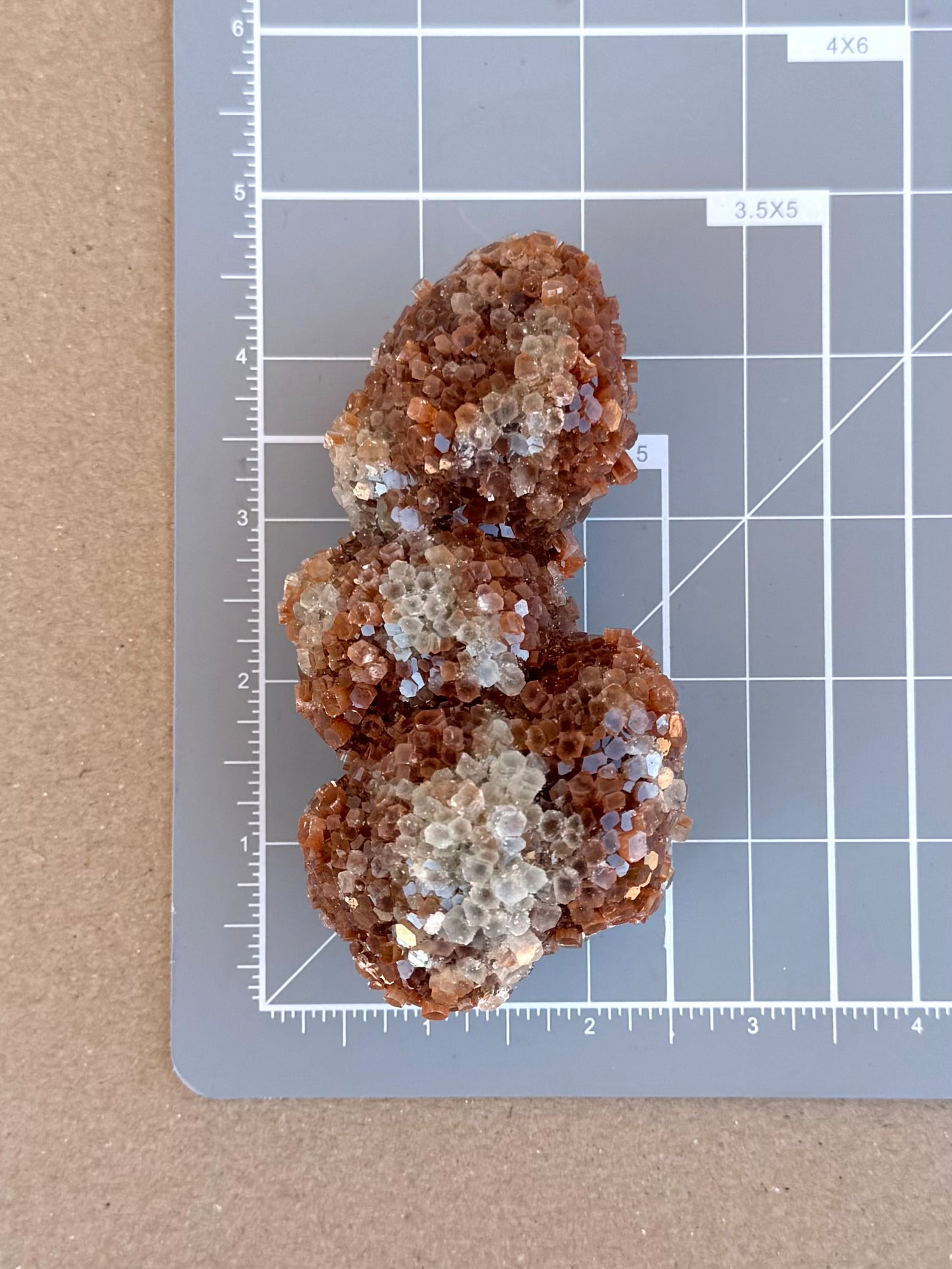 Scale image of the piece on a measuring mat, measuring a bit over four by two inches.