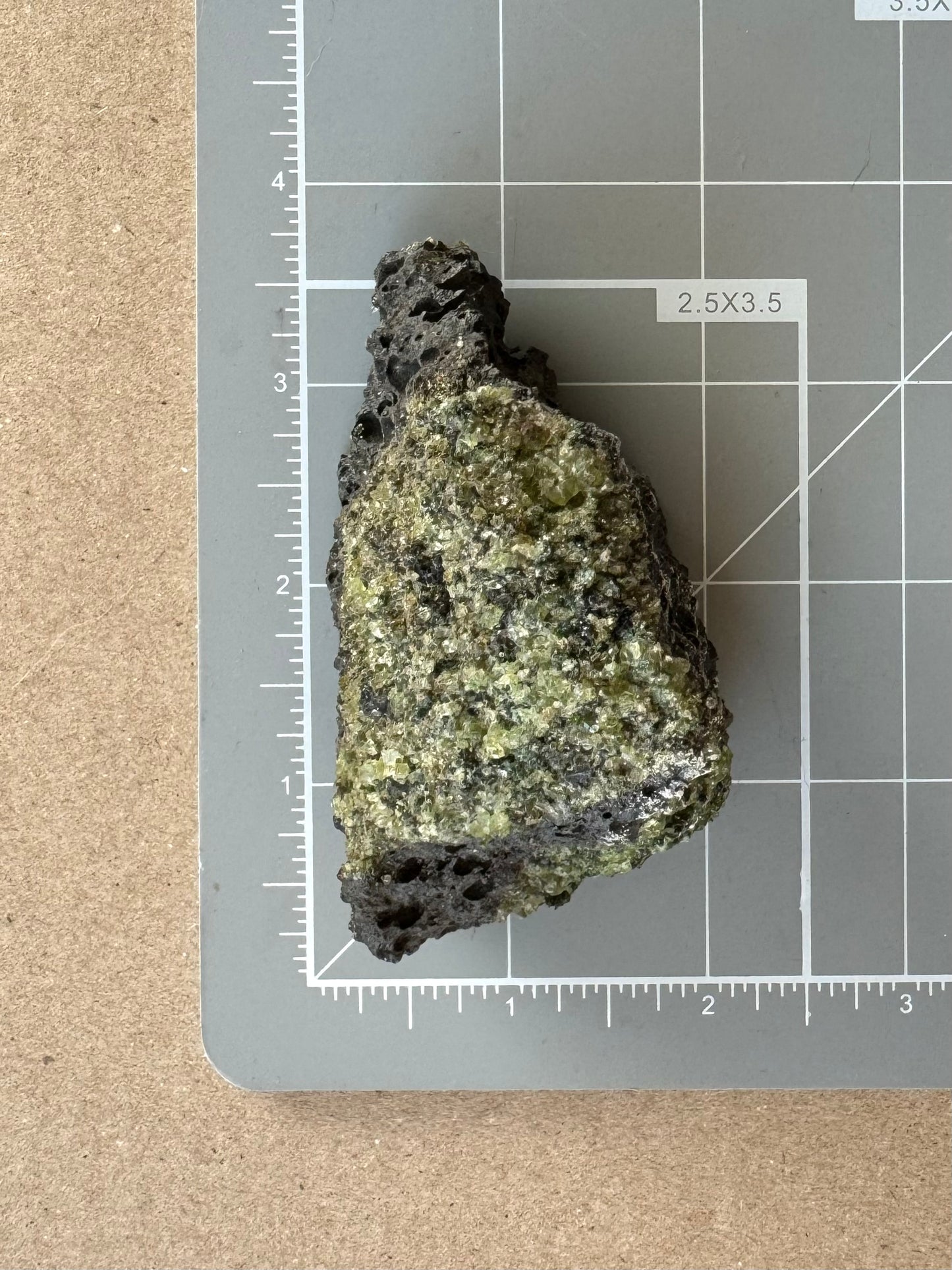 Scale image of the piece on a measuring mat, measuring over three inches long including the long pointed corner, and tapered from over an inch and a half at the bottom to a half inch at the tip.