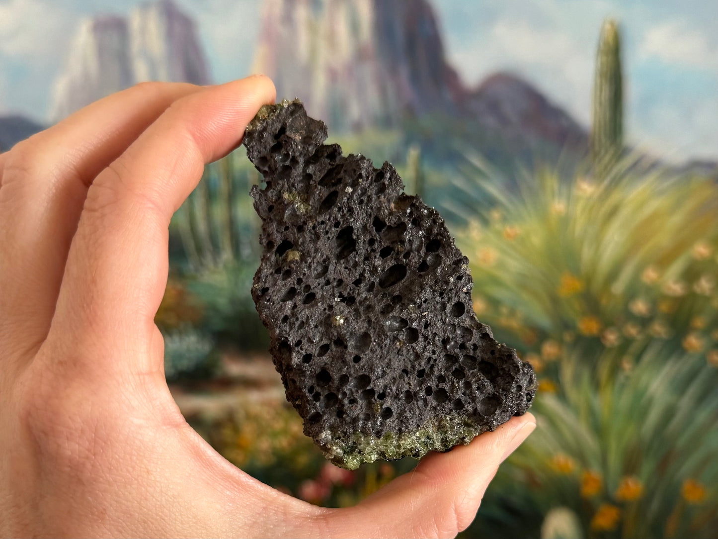 A long triangular side of the piece, entirely volcanic rock with good bubble holes, and olivine visible on the end.