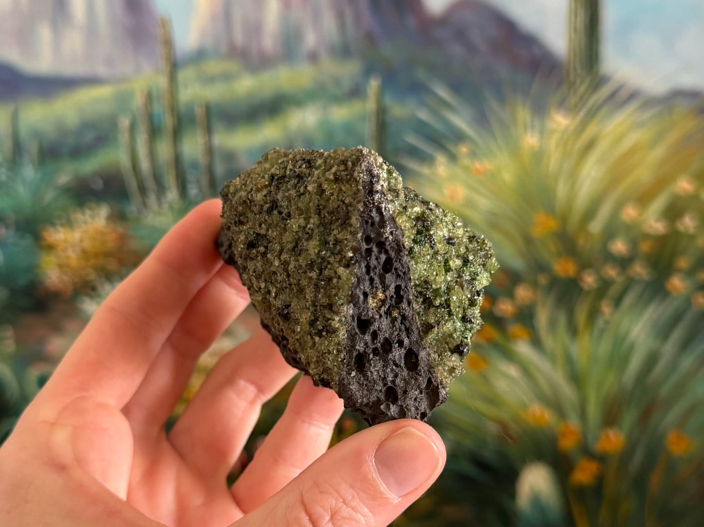 A view of the piece with one thin face of volcanic rock, gemmy peridotite on the righthand face, and lower quality peridotite of the left face.