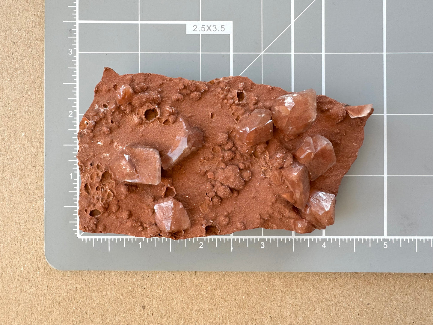 Scale image of the piece on a measuring mat, measuring about four by two and a half inches