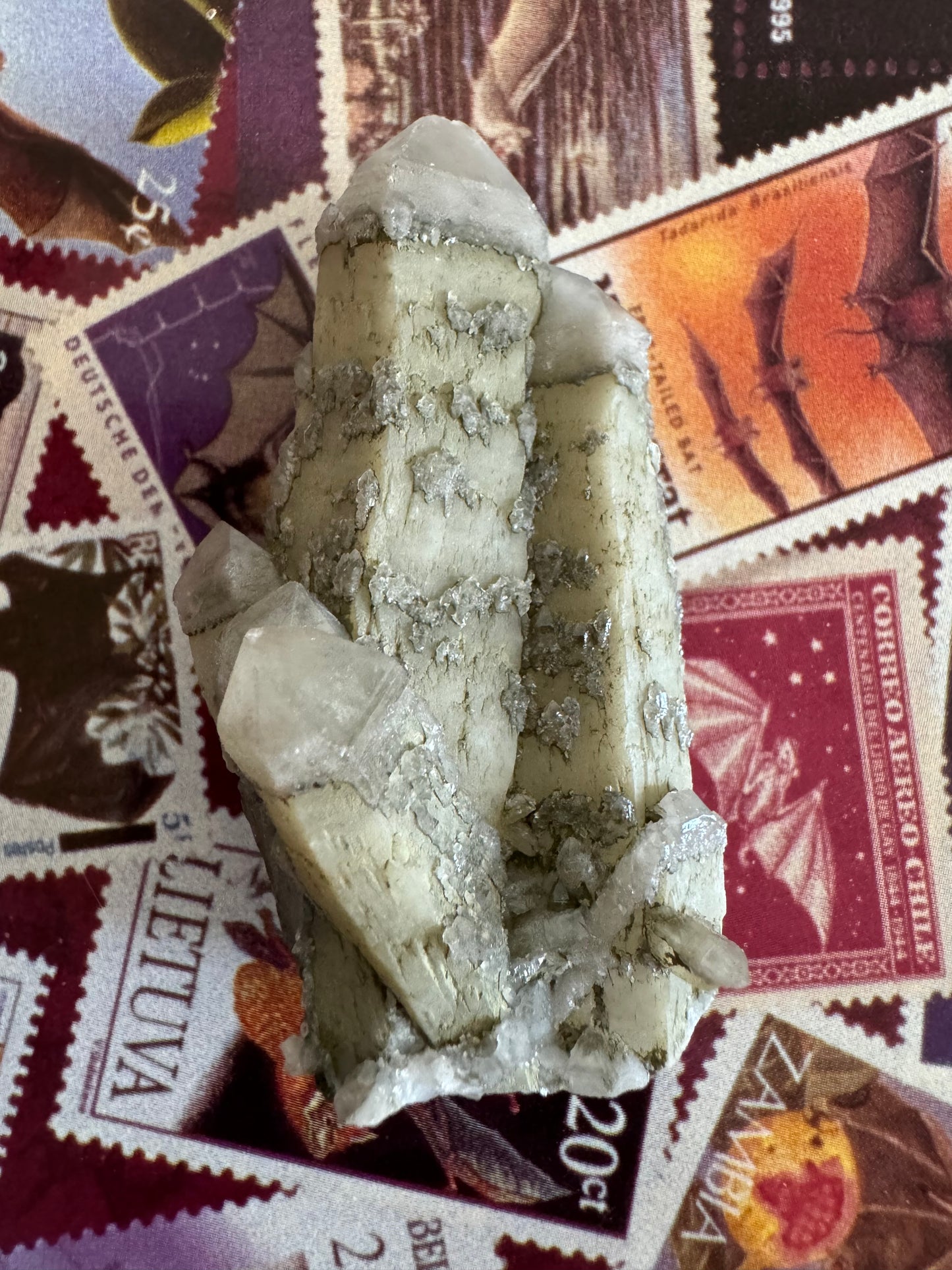 A cluster of quartz points close together and intergrown, with a dull luster and a gray-tan coloration. The piece appears near-opaque with inclusions, with better translucency in the sceptered tips of the points.
