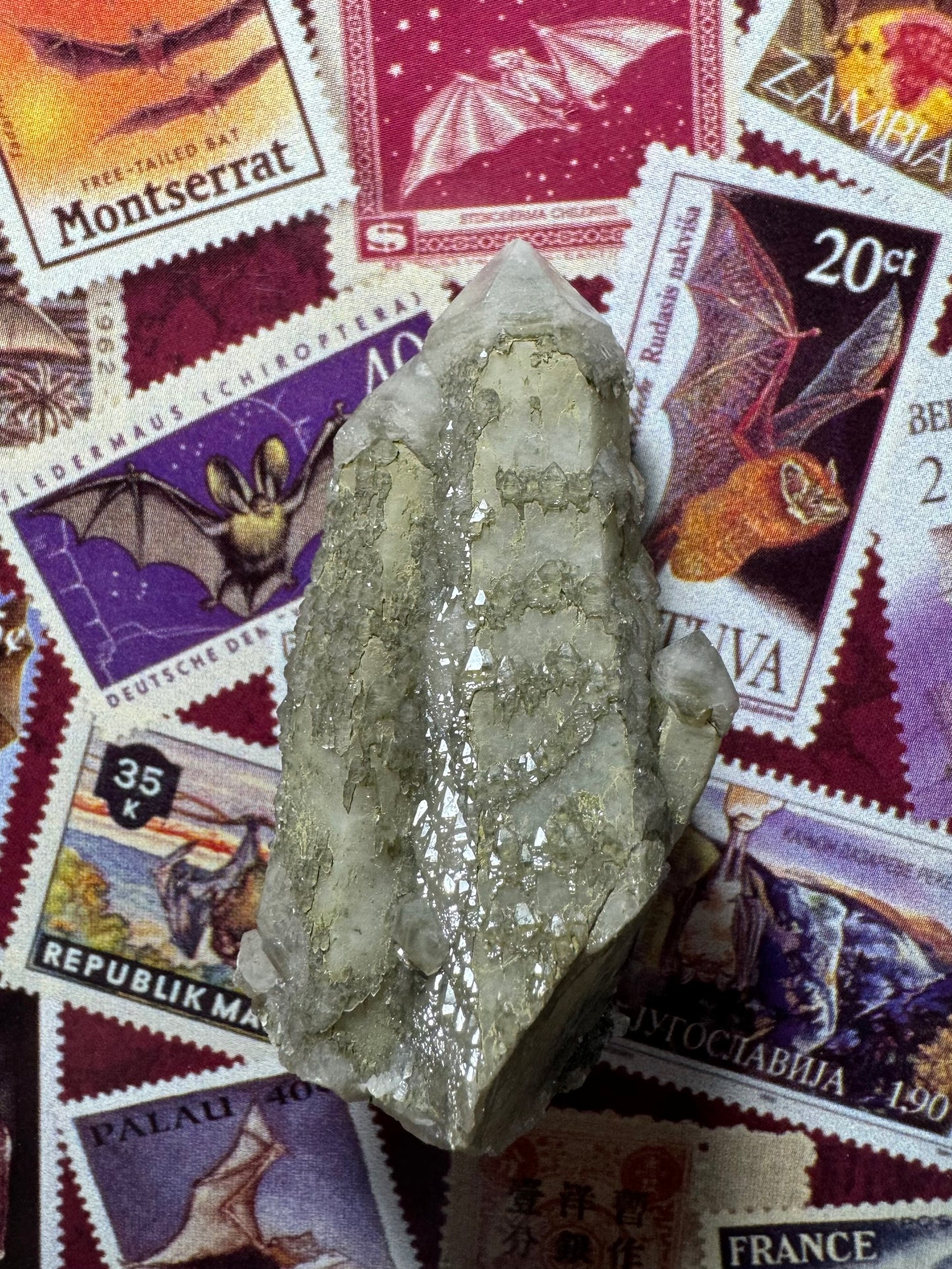 The piece with light shining on it so that crystals between two points are reflecting, highlighting a bunch of triangular faces on the tips of sprouting growth.
