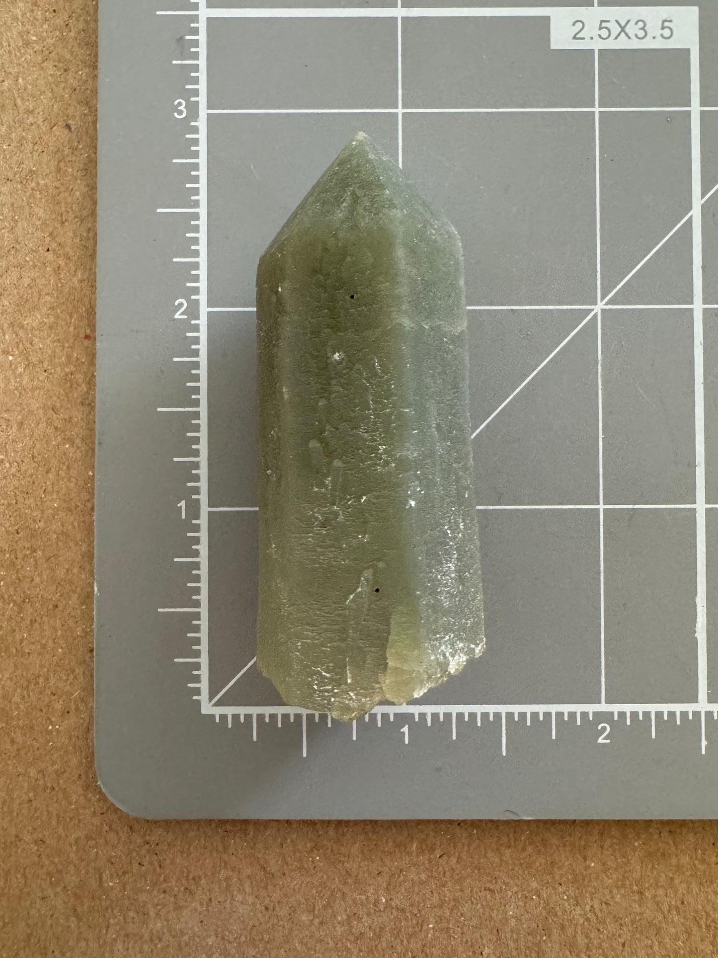 Scale image of the point on a measuring mat, showing it is over two and a half inches long, inclusive of angled broken base