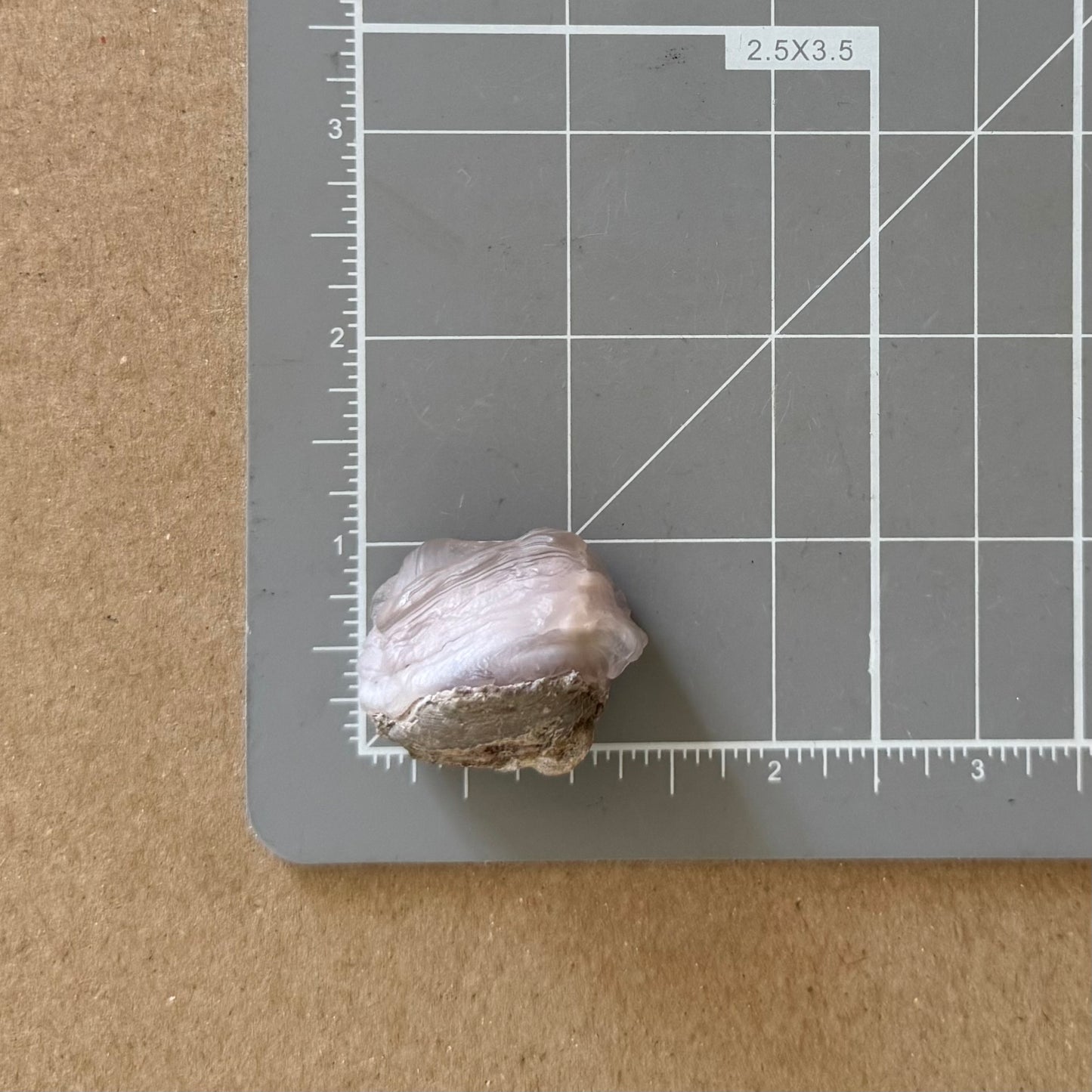 The piece on a measuring mat, measuring a little over an inch square.