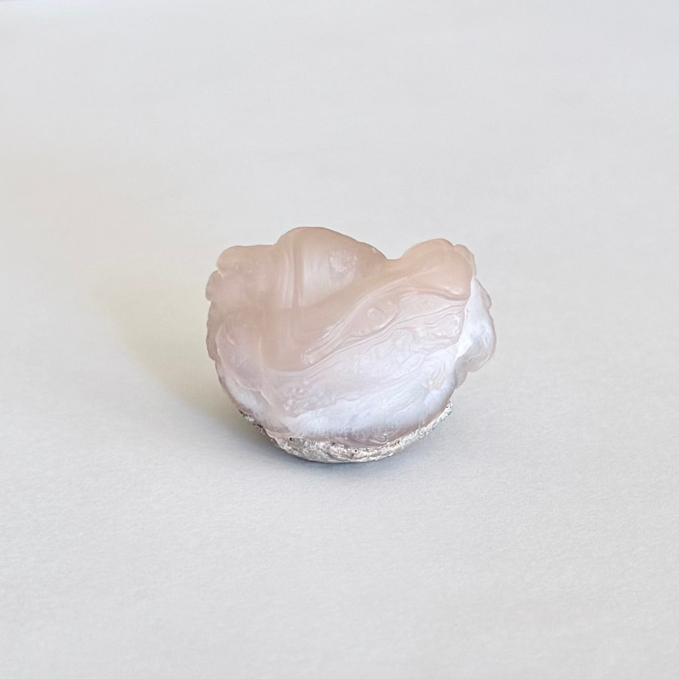 A more distant view of the specimen, showing the bulbous side. The angle shows a more white side with thin complex banding.