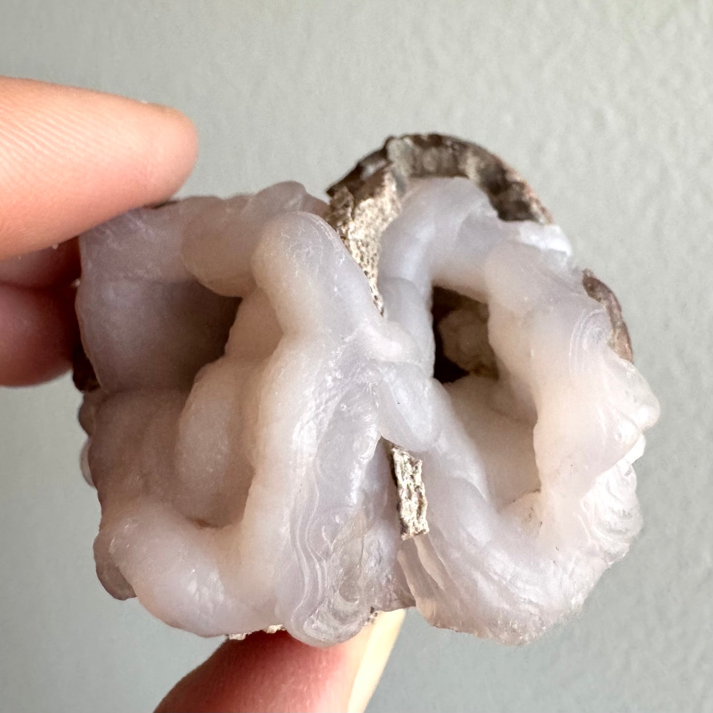 View into the thinner of the two open chalcedony formations, a deep and dark interior with lumpy forms inside. The edges of the two formations have very good swirling form, with a light chip of matrix wedged in the middle..