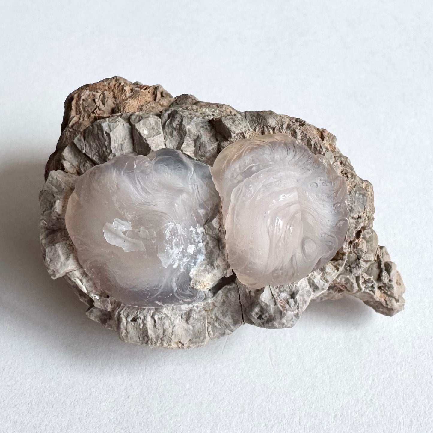 Detail view of the piece, emphasizing the translucency of the chalcedony and showing the swirling pattern on the surface. One of the circles has some thin white overgrowth on the surface.