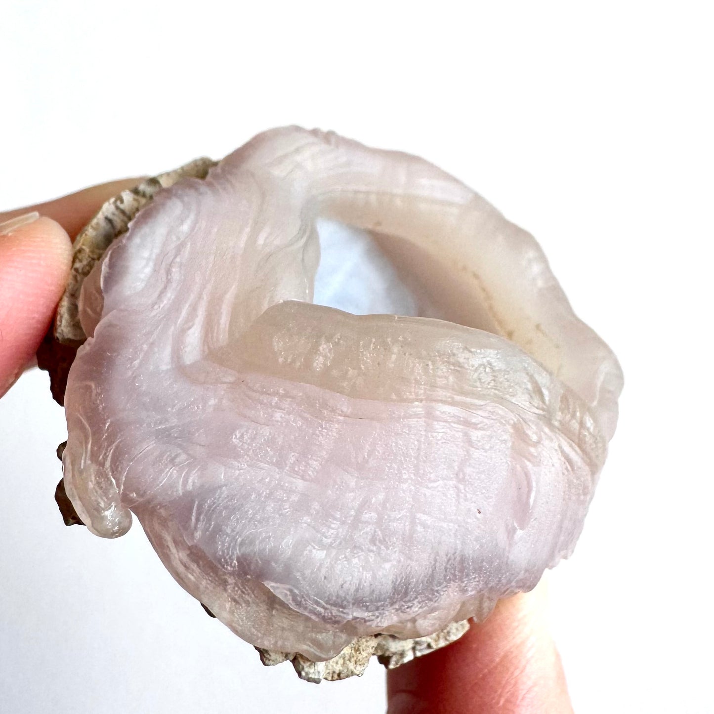 Detailed side-view of the specimen, the chalcedony extra fleshy textured. Horizontal banding is cut with vertical lines that give the side the appearance of loose wrinkled skin.