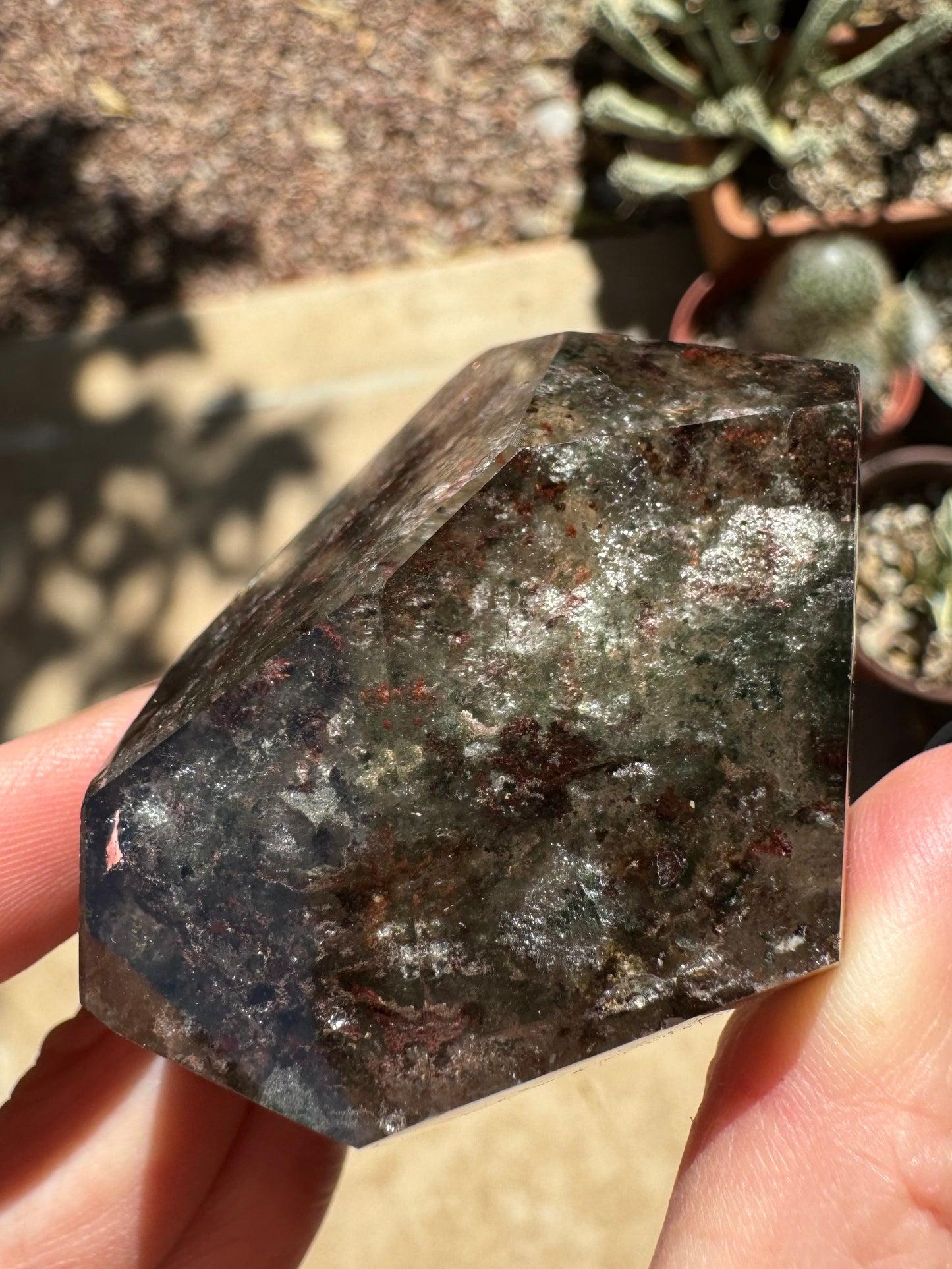 An end of the piece, with white inclusions behind wispy green and chunky dark brown chlorite