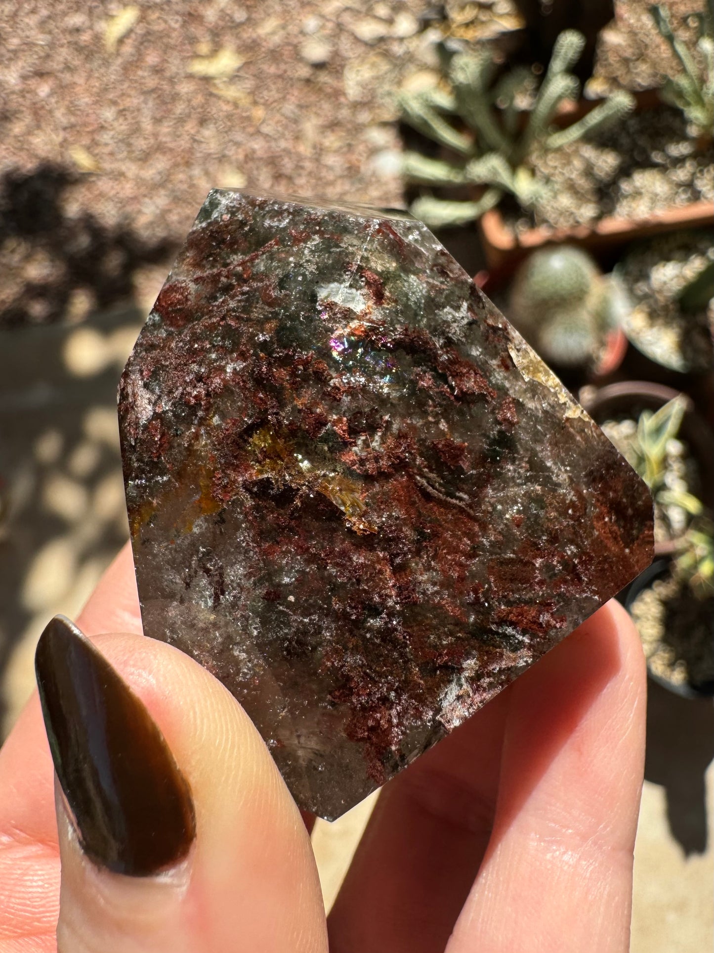 An edge of the piece, heavily included with red-brown inclusions, with some green inclusions.