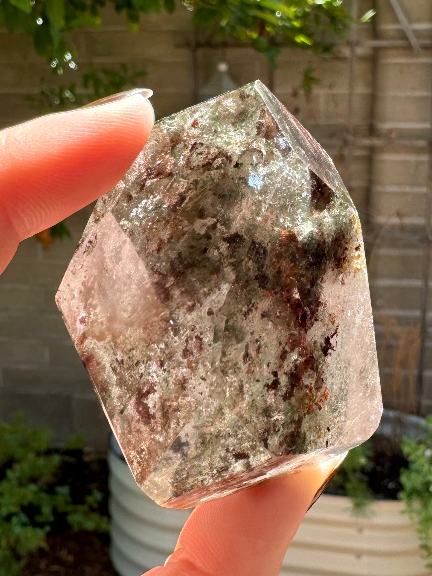 Another side of the garden quartz with light greenish and red-brown inclusions scattered in colorless quartz.