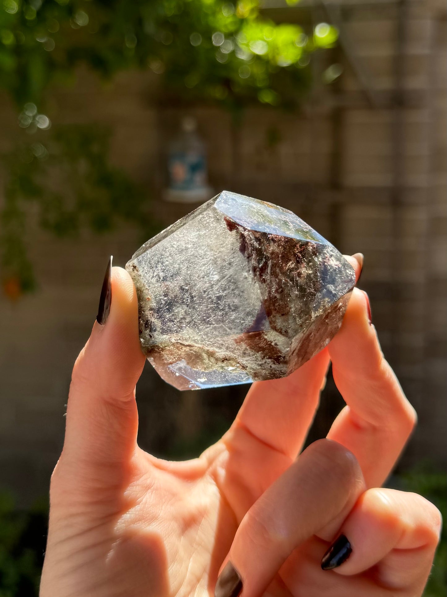 Looking down the end of the piece, with wispy inclusions illuminated in the colorless quartz. The left side is more opaque with dark inclusions