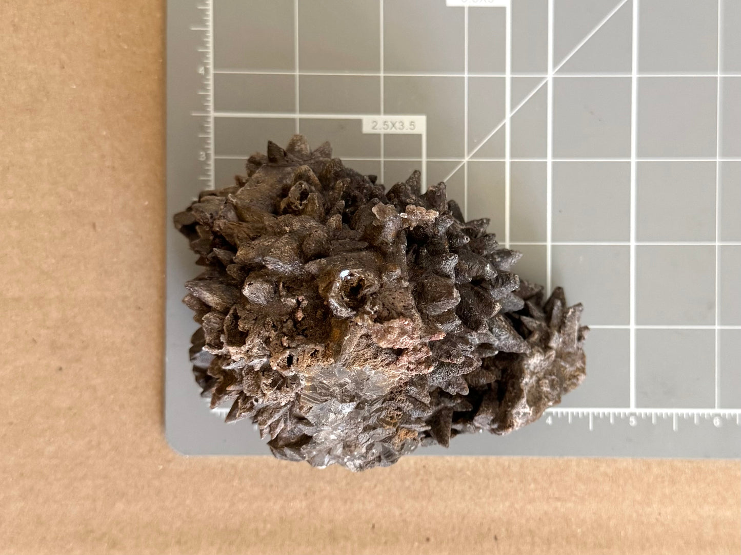 Scale image of the piece on a measuring mat, measuring about four inches wide and three inches tall.