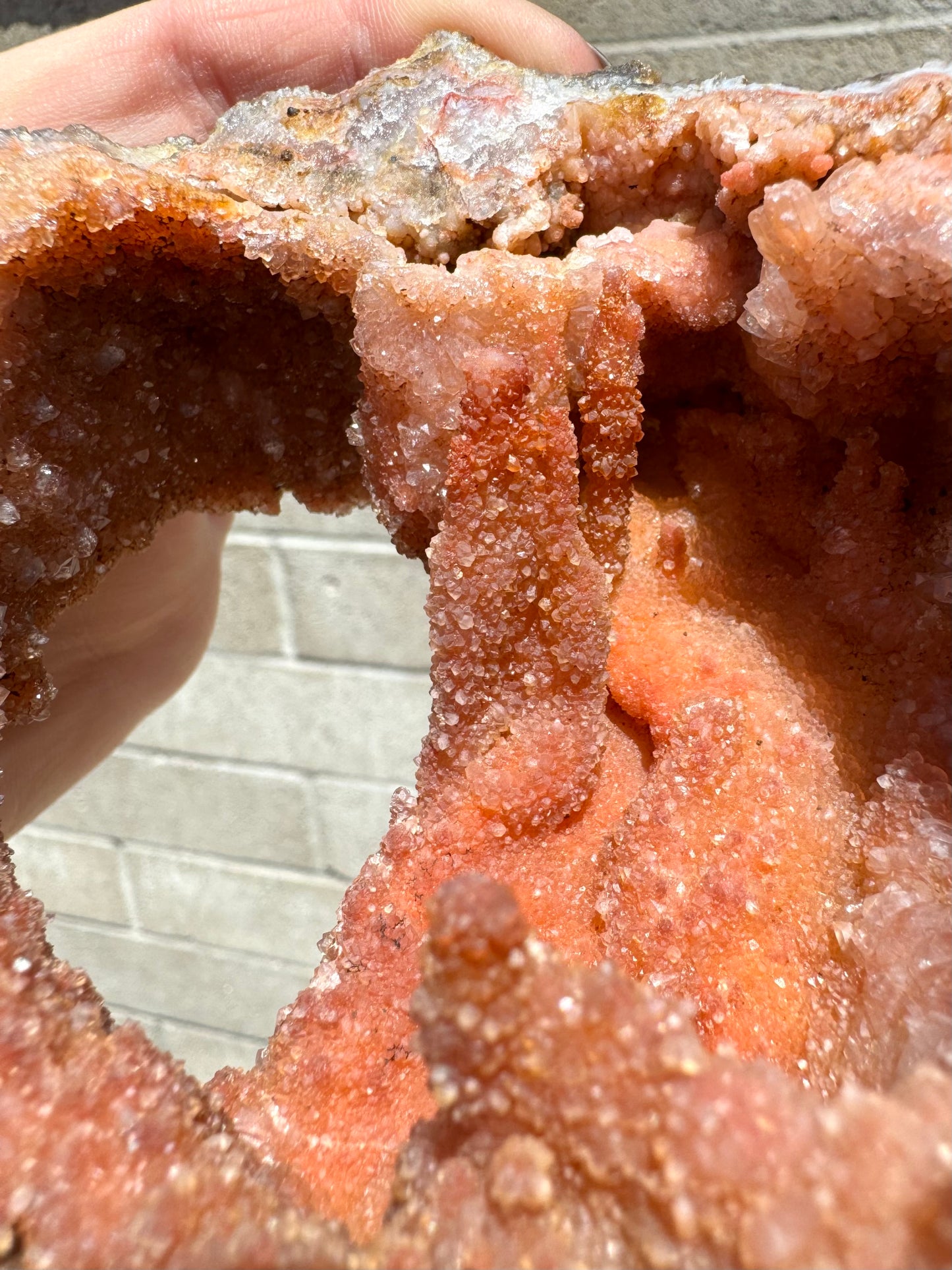 Detail of some stalactitic growth in the geode, covered with grainy crystal growth.