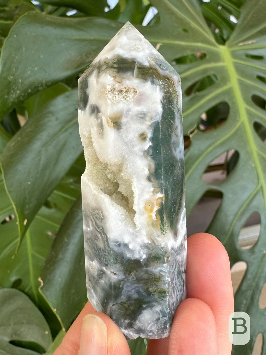 Option B, tower angled with the cavity on the left, with a forest-green mossy inclusions in a thick band going around it.