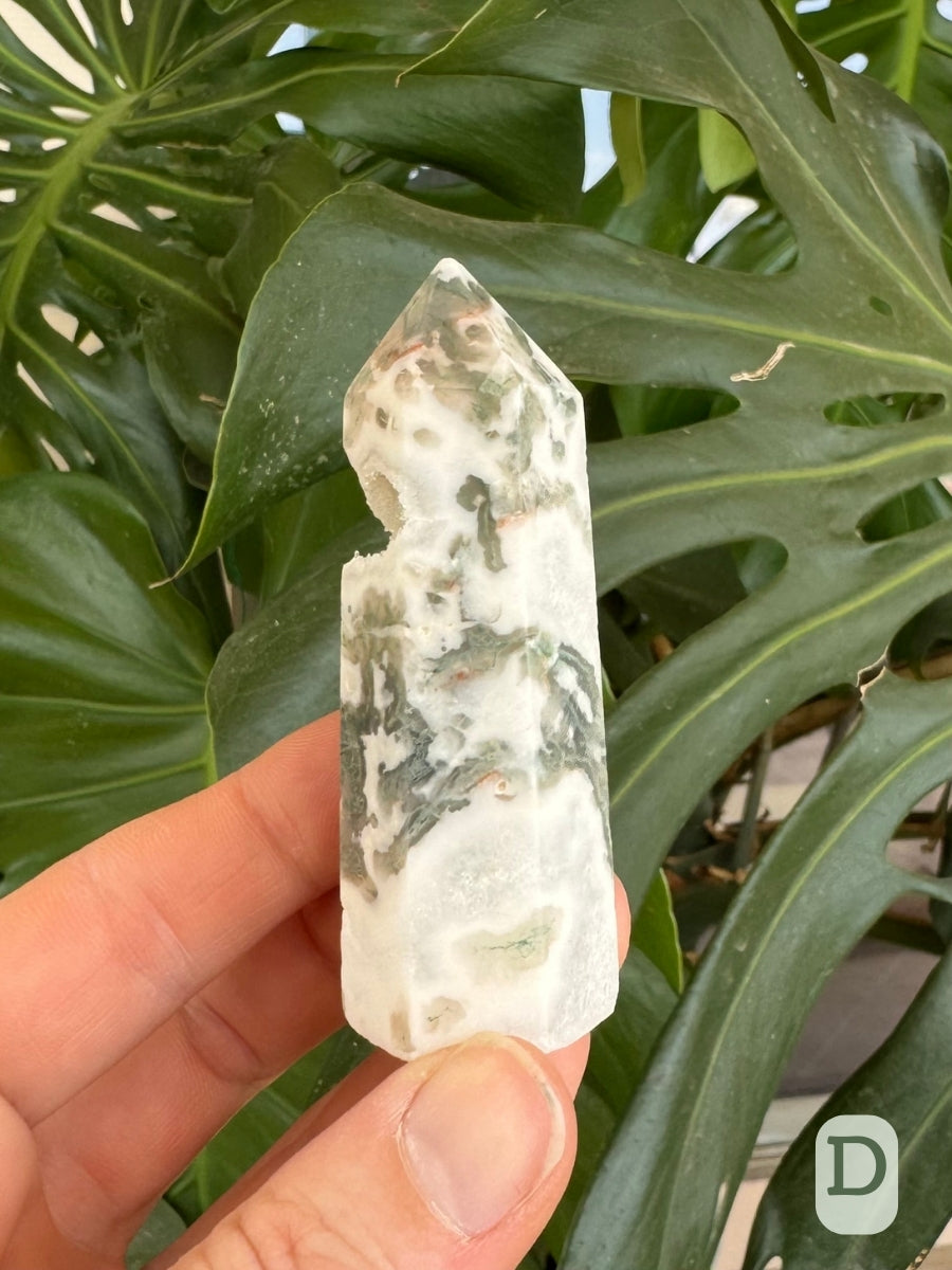 Option D, side of the moss agate tower with some more translucent crystalline growth near the base, and green inclusions striped through white agate.