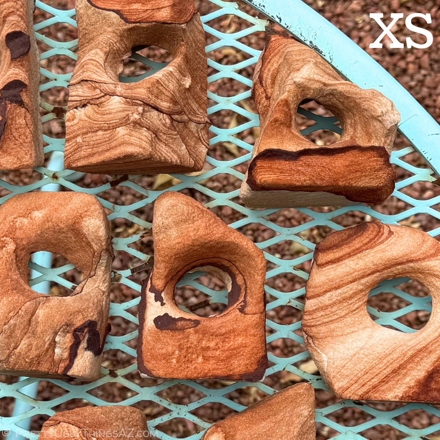 Small red sandstone arches spread over a tabletop, with similarly colored gravel under them. An XS in the corner indicates this is the extra small size.