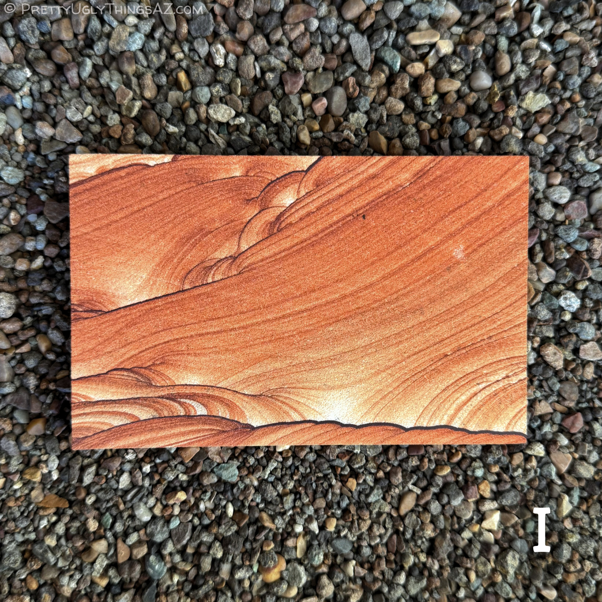 Option I, a standard rectangle with good vibrant orange-red color. Thin layers sweep diagonally across the middle of the piece, with looping and scallop patterns along the edges, accented with thin dark iron bands.
