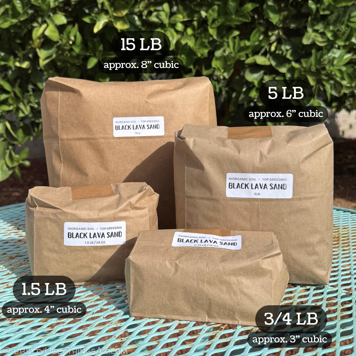 Four brown paper bags full of black lava sand arranged on a garden table, demonstrating the different sizes available. The smallest is three quarters of a pound, approximately three cubic inches. The second smallest is twice that volume, one and a half pounds which is approximately four cubic inches. The third largest is five pounds, approximately six cubic inches. The largest size is fifteen pounds, which is approximately eight cubic inches.