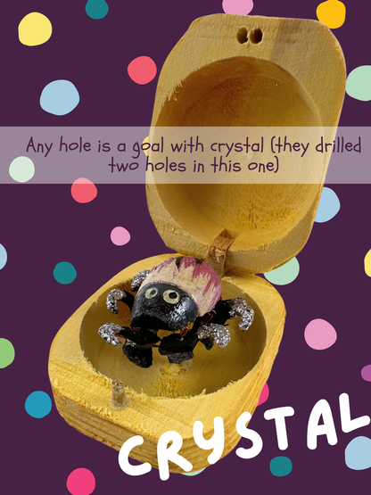 Mauve-pink bug with white streaks and black on the back, named Crystal and captioned "Any hole is a goal with crystal (they drilled two holes in this one)"