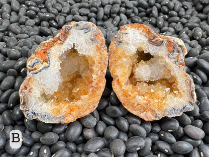 Option B: An oval pair of geodes, lined with chunky colorless druzy with yellow-orange iron staining through half.