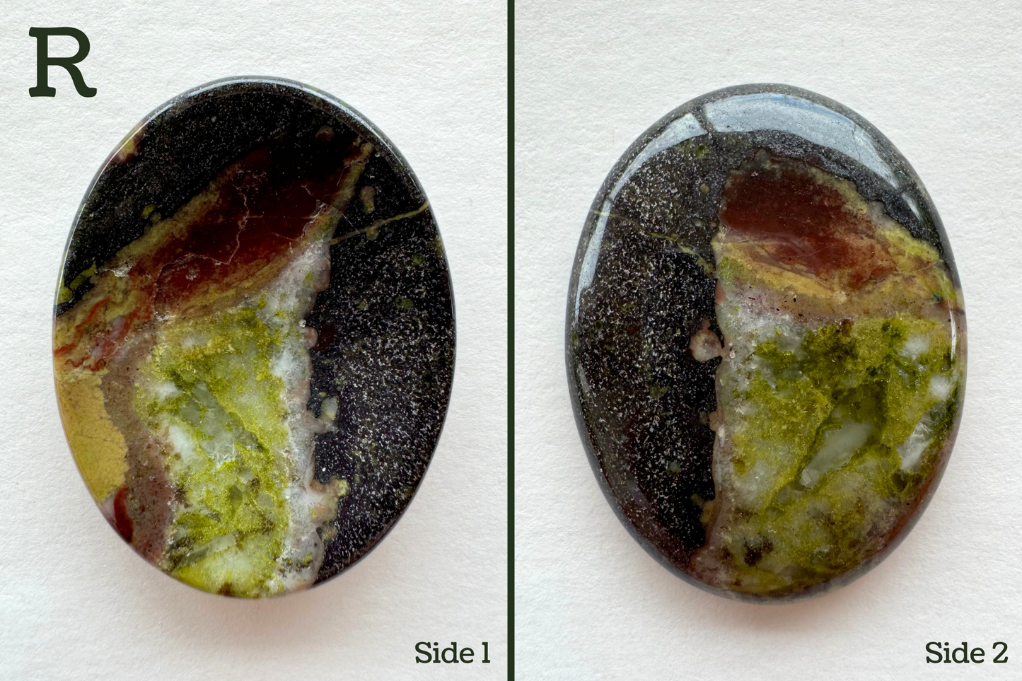 Option R, a grainy dark gray base color with a large green section with some aggregate crystal structure visible. It is lines with white on one side with a larger dark red spot and the top.