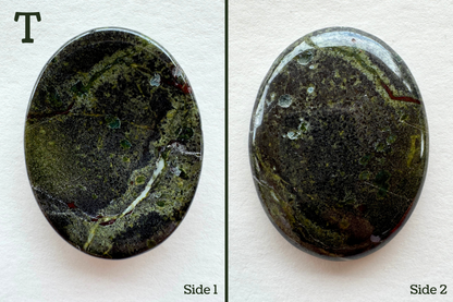 Option T, a mottled grainy gray and green base color with a white veining and a vein that is part red and part lime. In is bordered by lighter lime. There are several pocks of crystals removed from the surface, and several lime and blue-green spots across the surface.