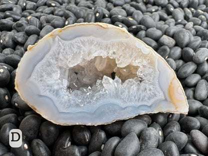 Option D: Detail of the other half of the geode, lined with well-formed quartz crystals with some small pieces of black mineral.