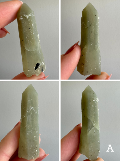 Option A, four views of a greenish-gray near-opaque point with some sprouting growth forms on the surface. Some natural fracturing is visible but does not endanger the piece. Near the base are some irregular black crystals There is a cluster of small glittery rice-grain shaped quartz crystals near the tip, and sprinkled around the surface of the piece.