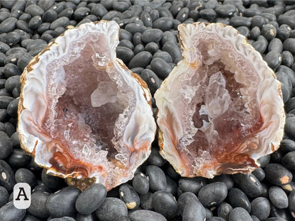 Option A: tear-drop shaped pair with white feathery pattern along the edge turning into swirling red hues at the base. There is a large quartz crystal inside the geode.