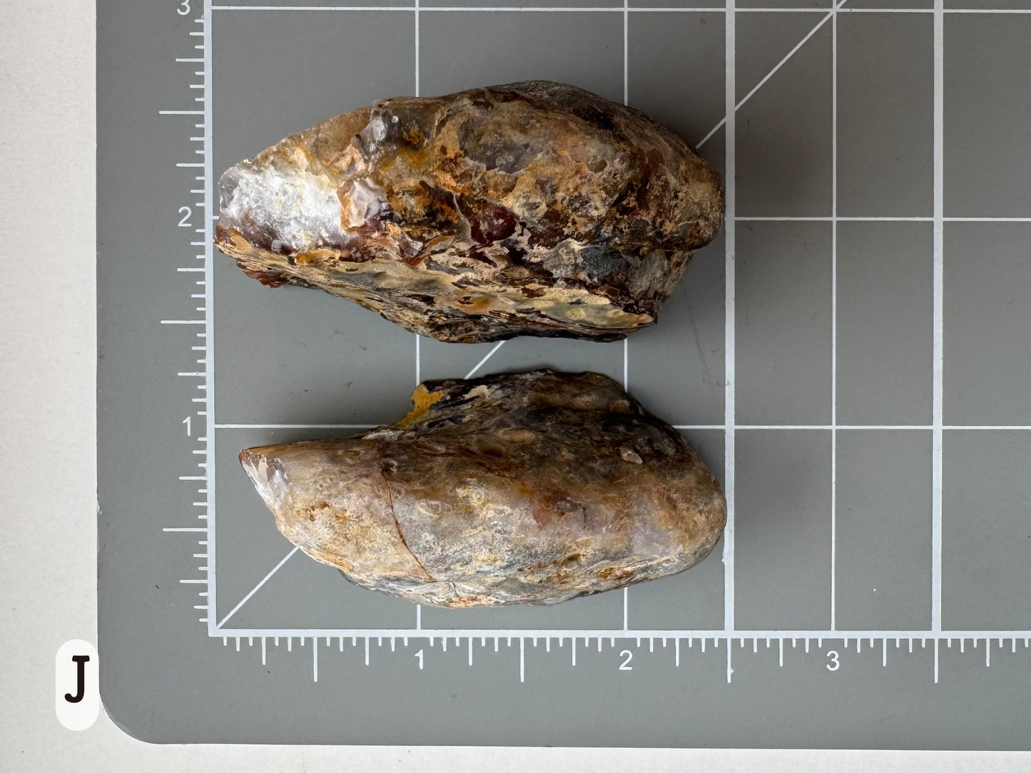 Option J: Scale image of the geode pair face-down on a measuring mat, measuring approximately two inches long.