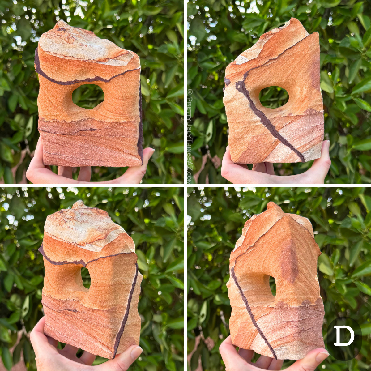 Option D, a blocky squat rectangular arch with a rough slanted top. The piece has color divided in three sections like candy corn, the bottom third a purple-tinted orange, the middle orange, and the top near-white. A couple angular bold dark iron bands cut across the faces. The sandstone has subtle layering.