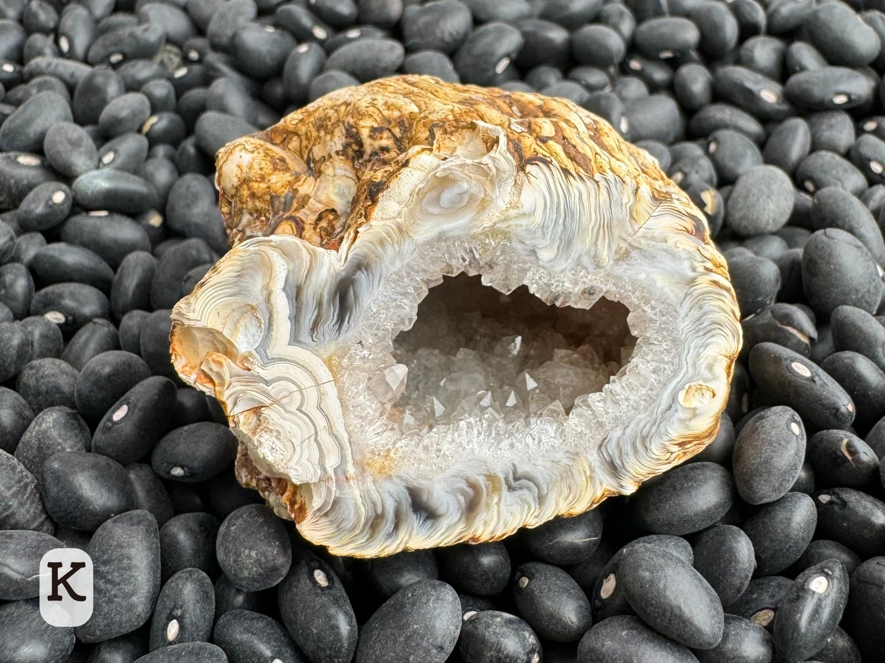 Option K: detail of one of the geode halves, with excellent feather geode patterning along edges and some rings of agate at one end.