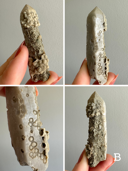 Option B, four views of an opaque off-white straight quartz point  One half of the piece has a smooth surface with round and ring-shaped indentations. The other half of the point has a bumpy crust growing on the tip and base, and between them the quartz surface is inverted with a rough sandy surface. a few small crystals poke out of this area.