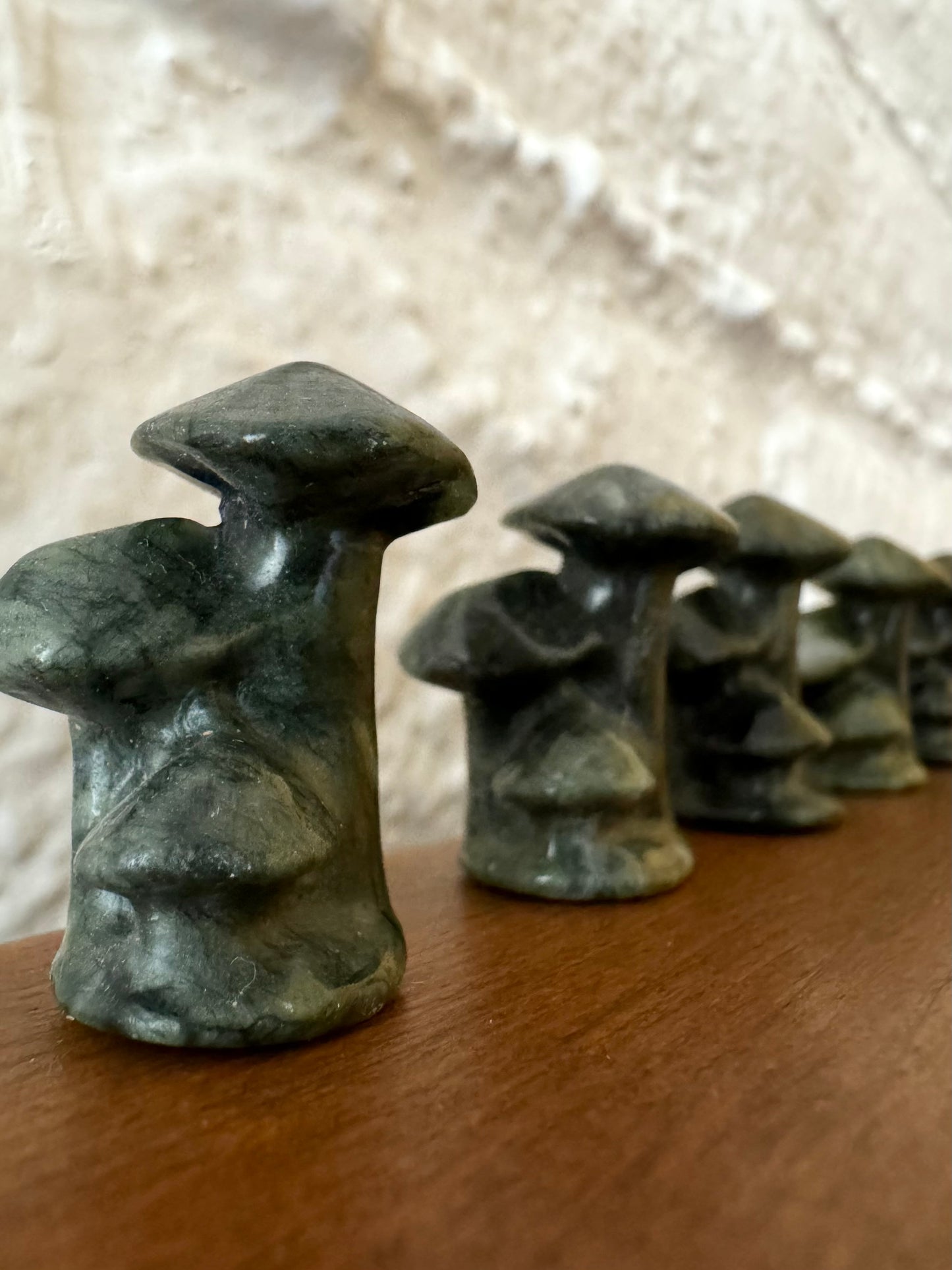 Angled view of dark green mushroom trios lined up in a row