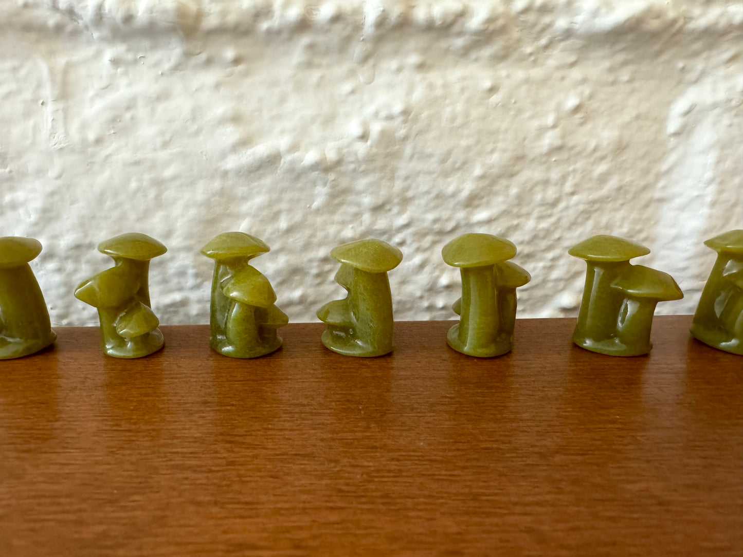 A more distant view of light green mushroom trios lined up in a row, showing the material is fairly even without much variation.