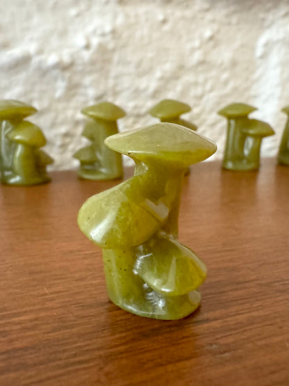 A detail view of a light yellow-green mushroom trio, showing slight translucency and mottling to the material