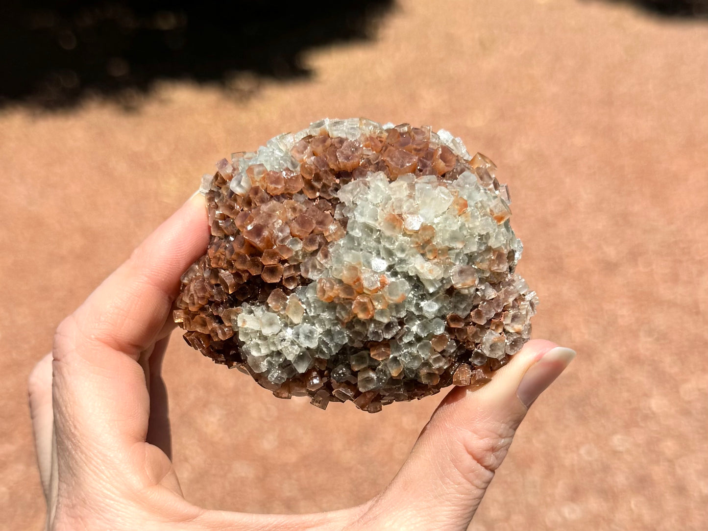 A side with white and red-brown coloration, with red tint to some of the white crystals at the middle.