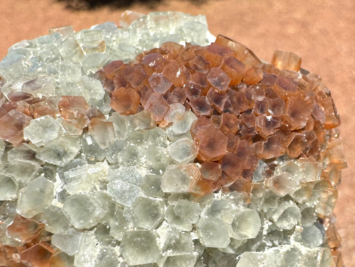 Detail of the transition from white to red-brown crystals. Some crystals are part white and part brown. Small white inclusions gather in the cracks between crystals.