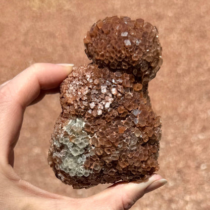 Another angle of the piece, shaped like three large rounded lumps. There is a patch of broken crystals in the middle. Near the bottom is a patch of white crystals.