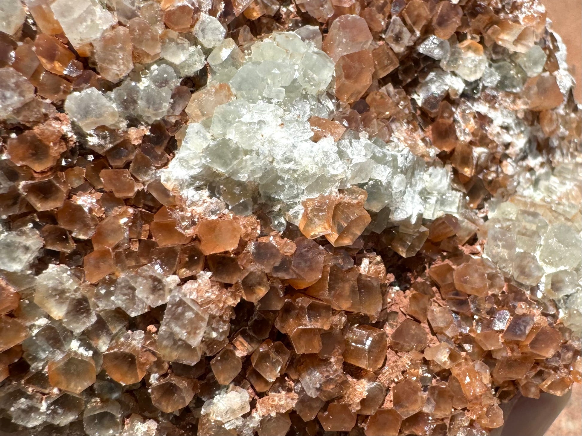 A detail view of the surface texture showing crystals oriented in different directions, and a patch of white overgrowth on the piece.