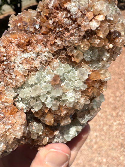 Detail of white and red-brown crystals, showing good translucency and pseudo-hexagonal form. The piece is dusted with a small opaque mineral.