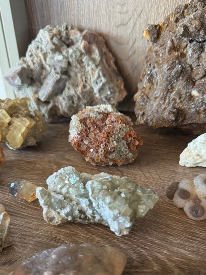 View of the piece on a mineral shelf, showing it has good color and luster relative to other pieces.