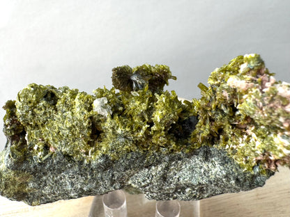 Close view of the top of the specimen with a good bow-tie formation atop epidote crystals with an irregular colorless mineral below it.