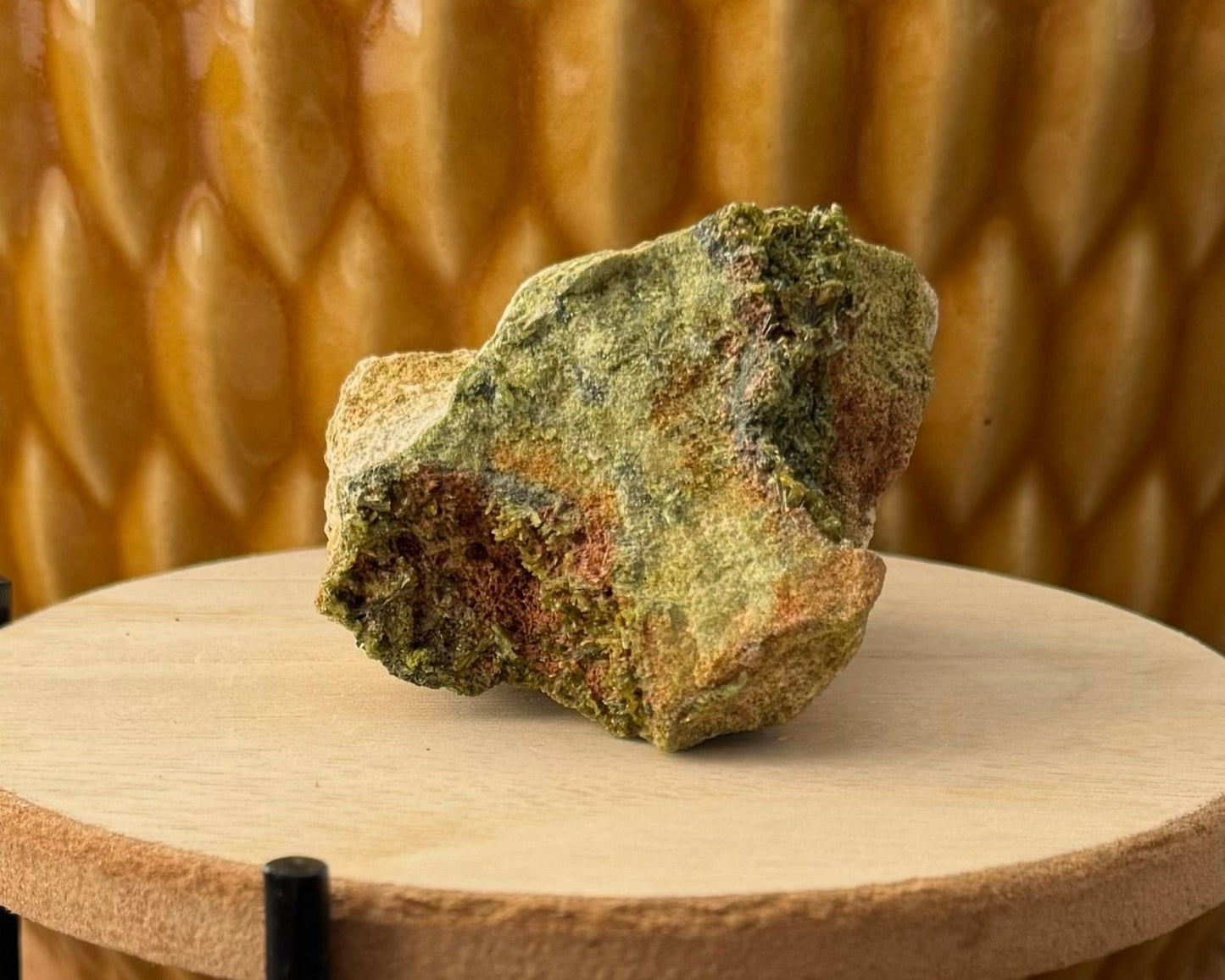 A tapered side of the specimen, matrix with green and orange-brown coloration. Each side is inverted and has epidote crystals across part of it.